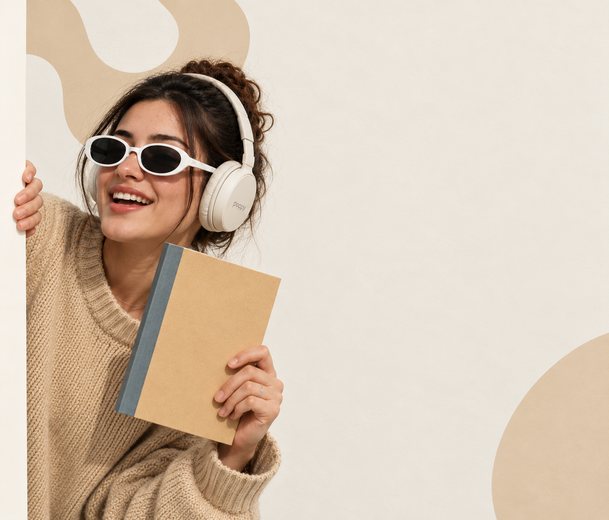 Smiling woman with headphones holding a Zen Series kraft notebook